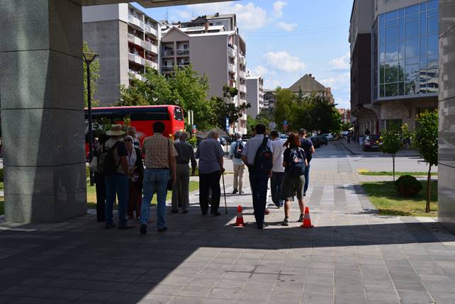 A group of people walking on a sidewalk

Description generated with very high confidence