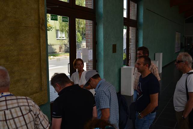 A group of people standing in a room

Description generated with very high confidence