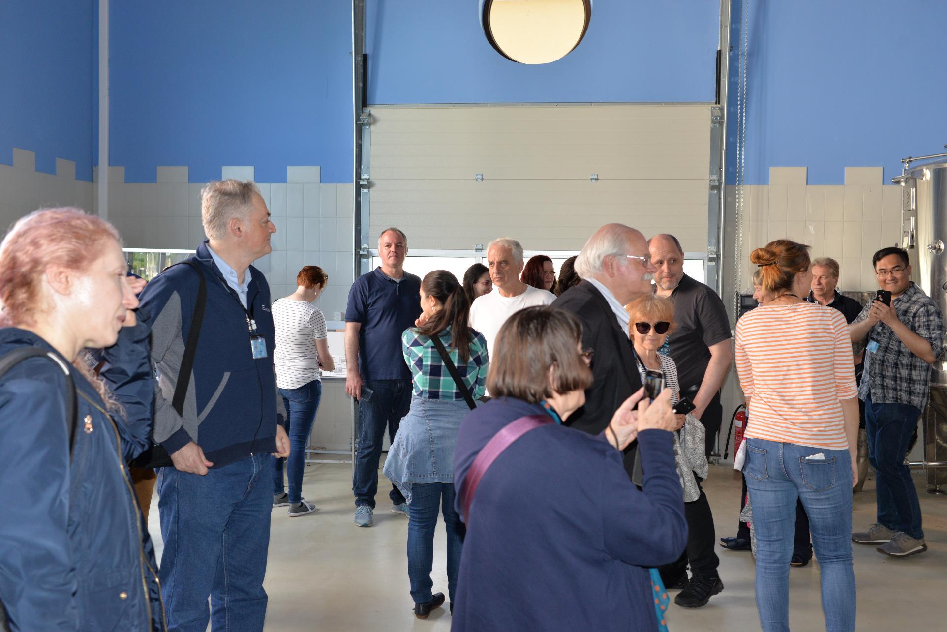 A group of people standing in a room

Description automatically generated